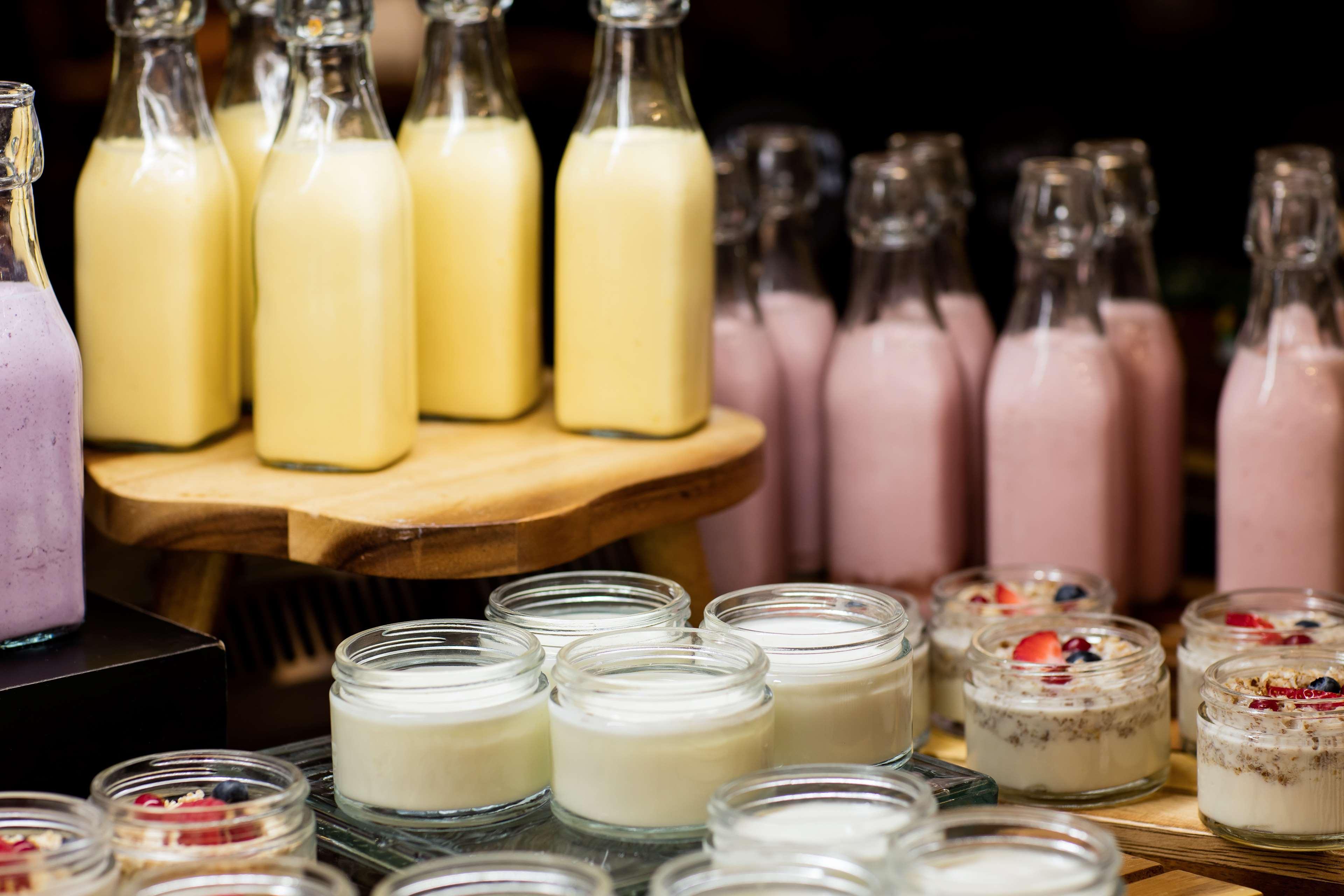 The Diplomat Radisson Blu Hotel Residence & Spa Manama Exterior photo The photo shows a variety of dessert items arranged neatly. In the background, there are several glass bottles filled with creamy liquids, likely yellow and pink in color, suggesting different flavors or types of drinks. In the foreground, there are 