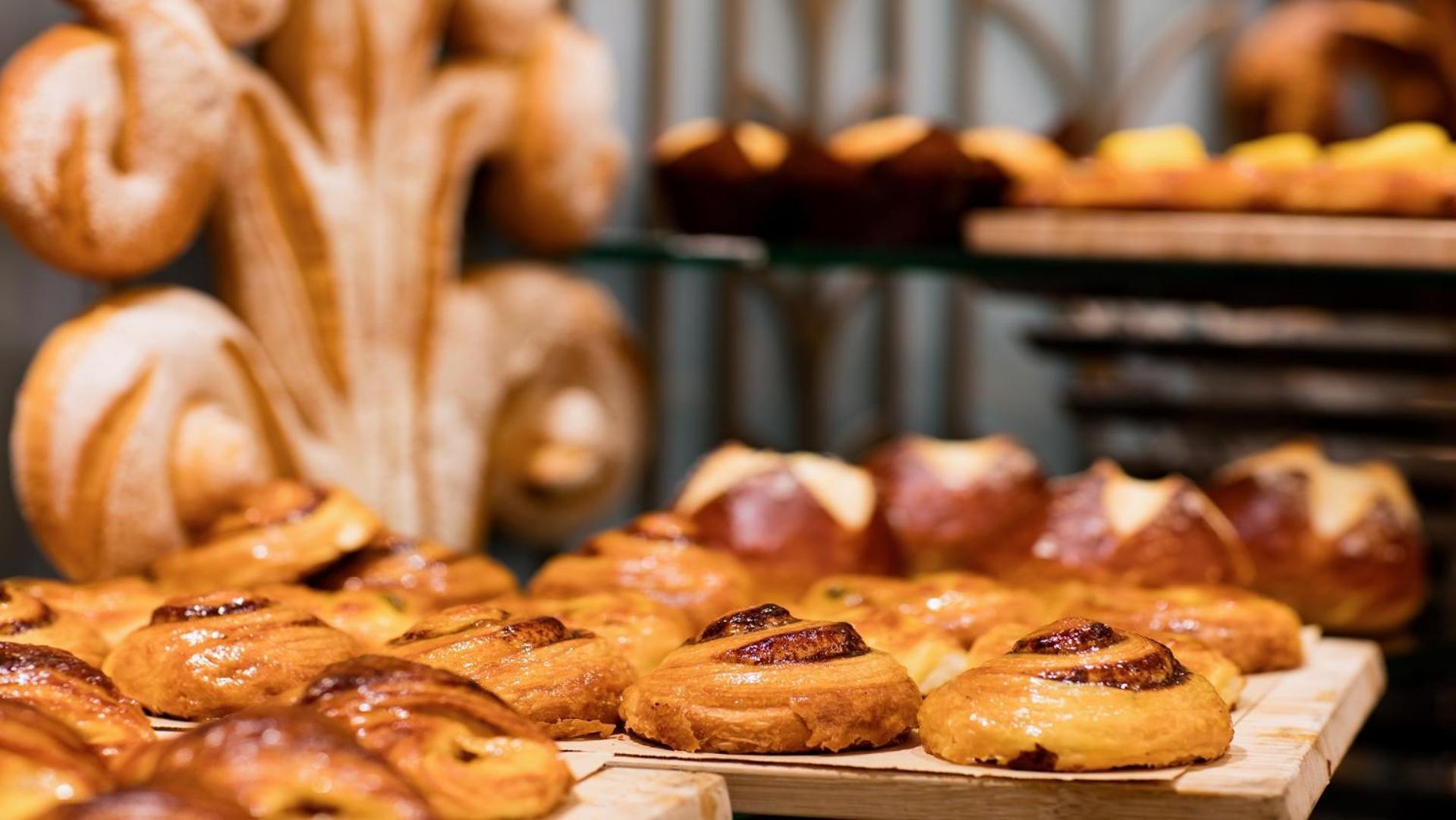 The Diplomat Radisson Blu Hotel Residence & Spa Manama Exterior photo The photo showcases an assortment of baked pastries arranged on a wooden surface. Prominently featured are various types of sweet rolls, likely including items like cinnamon rolls and fruit-filled pastries, characterized by their shiny, golden-brown 